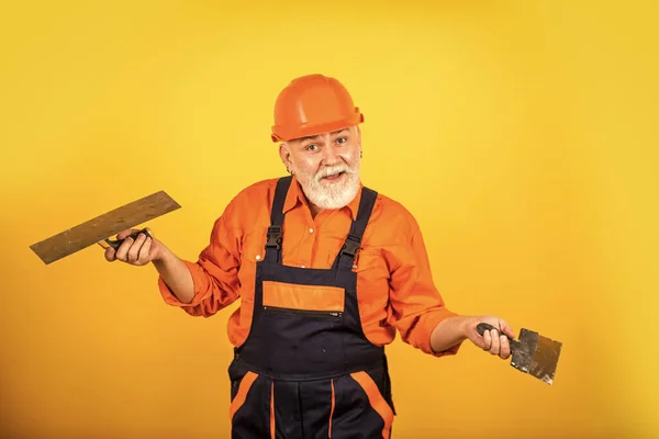 Ich denke, ich kann Ihnen helfen. Gipskelle Spachtel auf Gipskartonplatten. Gipser in Arbeitsuniform. Mann mit Spachtel. Prozess des Auftragens von Spachtelmasse. Putzwerkzeuge für Gips — Stockfoto