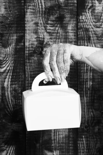 Ženské ruce držení dárek na hnědé vinobraní studio pozadí — Stock fotografie