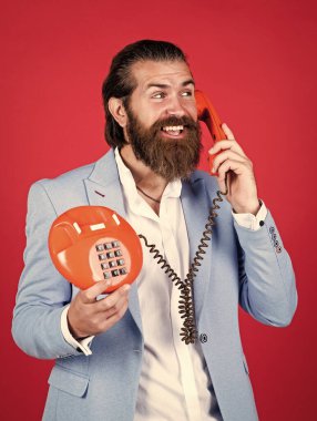 Telefondaki adam. Genç adam telefonda konuşuyor. İş adamı klasik telefondan konuşuyor. Erkek sabit telefondan konuşuyor. Modern yaşamda klasik teknoloji. Hat meşgul. En iyisi bu..