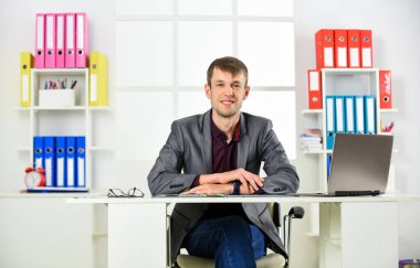 Dizüstü bilgisayarı olan bir adam ofiste çalışıyor, uzaktan kumanda konsepti.