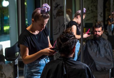 Adam, berber dükkanında saç kesiminde siyah saçlı, beyaz tenli bir adam.