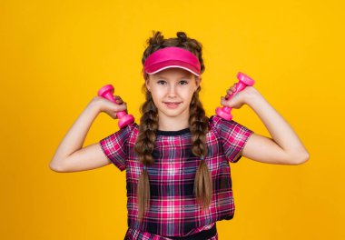 Güçlü ol. Genç kız eğitimi. Fitness 'e adanmıştır. Spor aletleri ve ekipmanlar. Sağlıklı ve aktif bir yaşam tarzı. Enerji dolu. Mutlu çocukluk. Şapkalı çocuk halterleri tutuyor. Dambılı çocuk