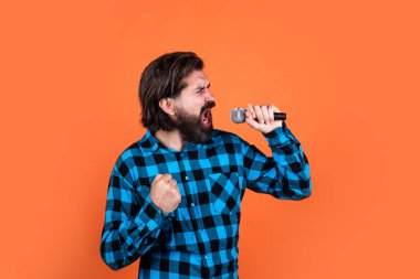 Ses ısıtması. Karaoke kulübündeki vahşi adam. Erkek mikrofonla şarkı söylüyor. Partideki yakışıklı hippi. Müzik. Olgun bir adam şarkı söyler. Ses sınıfları. Müzik tarzı. Sakallı adam mikrofonda şarkı söylüyor.