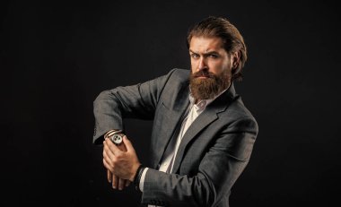Saat tamiri. Ciddi sakallı adam. Pahalı takım elbiseli yakışıklı ve başarılı bir adam. Elli saati olan tişörtlü adam. Takım elbiseli başarılı bir adam. İş adamı takım elbise giyer. resmi ofis yaşam tarzı
