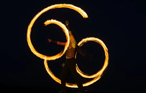 Fire Poi artista realizar carretes ardientes con resplandor, colas en movimiento en el cielo oscuro al aire libre, truco —  Fotos de Stock