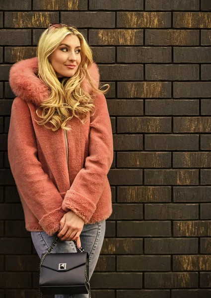 Hålla handväskan. Gatustil. vårens sommartrend. Fashionabel kvinna i rosa päls. kall årstid. Höst eller vinter look. vacker elegant kvinna promenader i rosa rock. Ung expertis — Stockfoto