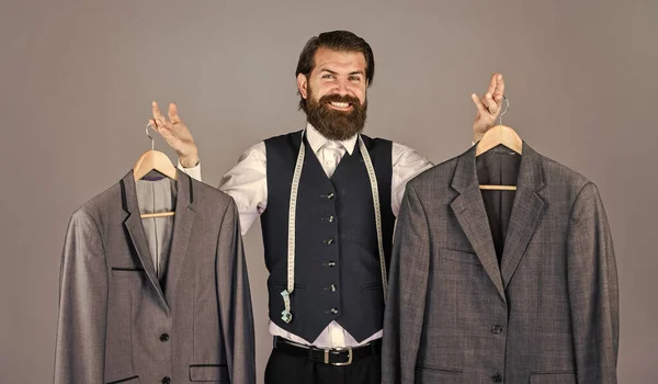 Tailor sewing. Handsome bearded fashion man in classical costume suit. Man in custom suit presenting expensive tailored tuxedo. Man clothing in boutique. Man with suit. tailor in his workshop