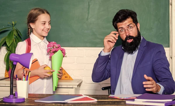 Aluno adorável menina com mochila transportar flores bouquet para o professor. Férias escolares. 1 de Setembro. Aluna agradecida. Saudações para o pedagogo da escola. De volta à escola. Congratulações de dia de conhecimento — Fotografia de Stock