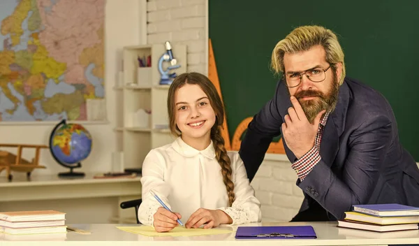 Emocionado por el conocimiento. de vuelta a la escuela. Niña y hombre contra pizarra. concepto del día del conocimiento. niño con maestro en el aula en la escuela. Feliz día de los maestros. profesor y colegiala en la lección —  Fotos de Stock