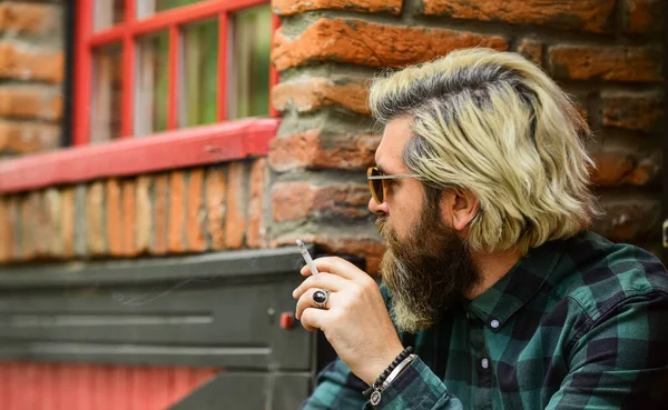 Détourner les yeux. Un homme fumant une cigarette. homme d'affaires à lunettes fumant la cigarette dans la rue. Sortez faire une pause-fumée. Bel homme élégant fumant à l'extérieur dans un cadre urbain. mode de vie hipster — Photo