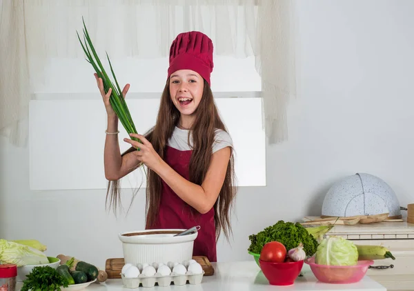 Lycklig flicka använda lök för färsk sallad, kulinariska — Stockfoto