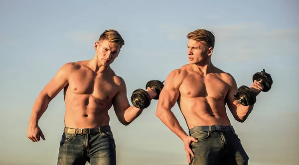 强壮健康的男人健美。双胞胎肌肉男。运动员性感的身体。肌肉发达的家伙带着杠铃和哑铃双胞胎一起训练发展肌肉力量和力量 — 图库照片
