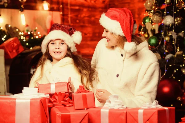 Het is het seizoen om Jolly te zijn. Vrolijk kerstfeest. Moeder en dochter houden van feestdagen. klein kind meisje met moeder in santa hoed. Kerstmis geschenkdozen. Open het cadeau. Gelukkig gezin vieren nieuwjaar — Stockfoto