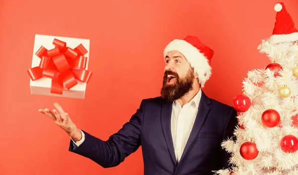 Entrega rápida de presentes. Caixa de presente com fita festiva arco caindo para a direita para a mão masculina. Conceito de serviço de presente. Enviar ou receber presentes de Natal. Homem barbudo hipster terno formal feliz celebrar o Natal — Fotografia de Stock