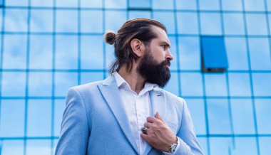 Modaya uygun vahşi hippi sokak ortasında resmi bir iş elbisesi giyer.