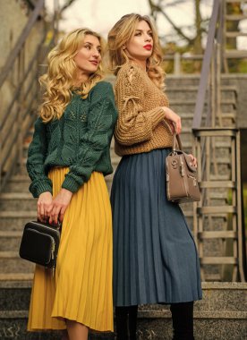 Birlikte dünyayı keşfediyoruz. Pileli trend. Etek ve kazak giyen kızlar. Kadın güzeli. Örgü giyim gençliği. Cazibe Havalı sonbahar kadınları dışarıda. Kız arkadaşlar yukarı çıkar. Sonbahar mevsimi renk eğilimleri