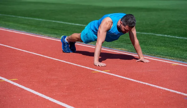 Esportes e rotina de vida saudável. sucesso desportivo. atleta do sexo masculino fazer exercício matinal. Exercício de flexões. desportista prancha ao ar livre. cuidados de saúde. O tipo musculoso faz desporto. homem na prancha. espaço de cópia — Fotografia de Stock