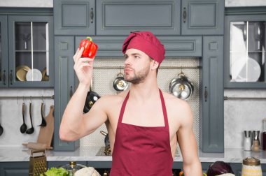 Sağlıklı yiyecekler benim görevim. Erkek şef doğal organik bibere bakar. Adam sağlıklı vejetaryen yemekleri pişirmeye hazır. Vitamin sağlığım için iyidir.