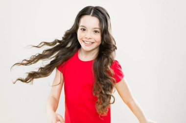 Moda güzeli. hippi çocuk. çocukluk mutluluğu. Uzun kıvırcık saçlı mutlu kız. Kuaför salonu. Cilt bakımı ve doğal saç. Küçük kız gülümsüyor. Rüzgarlı saçlar. Küçük manken. saç modası