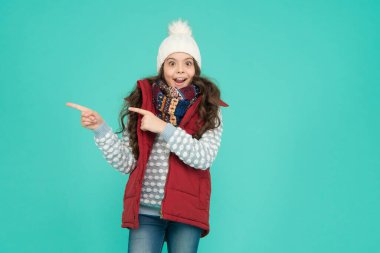 Orada xmas indirimi var. Yeni yıl tatiline hazırım. Hipotermi yok. Neşeli kız kıyafet katmanları giyer. Kış mevsiminde kalın giysiler. Soğuk hava tahmini. Çocuk moda alışverişi. işaret parmağı