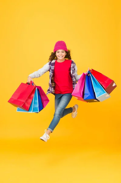 Chaque achat vous est livré. Enfant énergique transporter des sacs à provisions. Manipuler les sacs-cadeaux en papier. Emballez et emballez. Prix de gros. Vente et rabais. Achetez jusqu'à ce que vous tombez — Photo