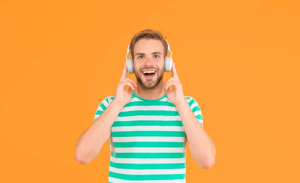 Ось що я називаю музикою. Щасливий хлопець слухає музику жовтого фону. Заручний чоловік любить музику в навушниках. Сучасне життя. Нова технологія. Розваги і розваги. Загублені в музиці — стокове фото