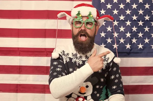 Buon Natale. Ciao. Stagione delle vacanze negli Stati Uniti. Fedeltà al governo. Felice anno nuovo. Il ragazzo felice festeggia Natale e Capodanno. Barba hipster uomo felice sorridente sfondo bandiera americana. Buone vacanze — Foto Stock