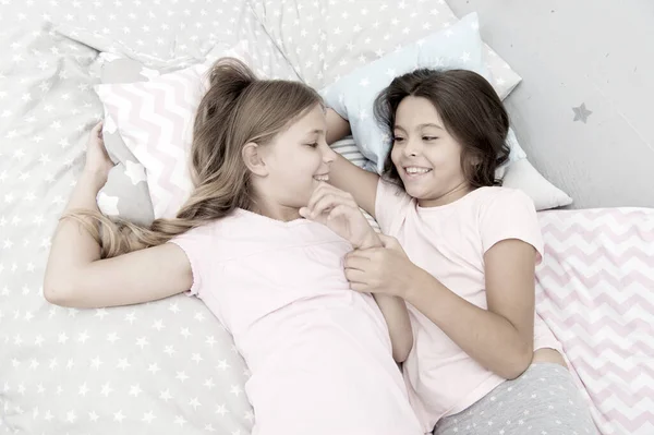 Hermanas felices niños pequeños relajarse en el dormitorio. Amistad de niñas pequeñas. Ocio y diversión. Divirtiéndose con el mejor amigo. Los niños alegre humor juguetón divertirse juntos. Fiesta de pijama y amistad —  Fotos de Stock