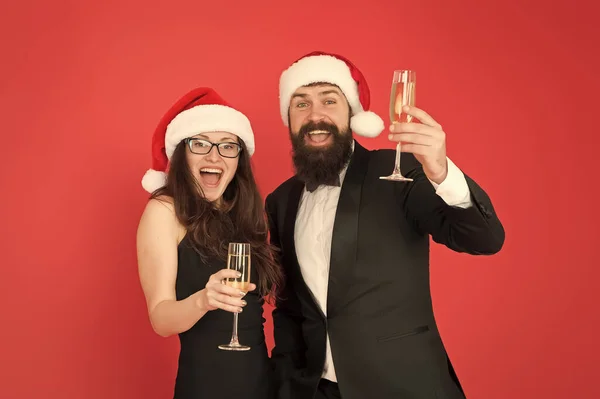 Irodai buli. Egy pár a céges bulin. Boldog új évet! Szakállas üzletember szmokingban és lány elegáns ruha iszik pezsgő vörös háttér. Téli parti. Őszinte üdvözletem. Boldog karácsonyt! — Stock Fotó