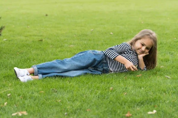 Söt liten unge bära casual mode stil ligger på grönt gräs naturligt landskap, sommar — Stockfoto