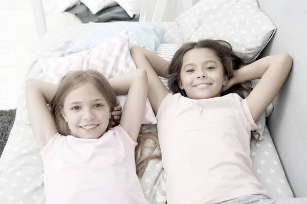 Att vara lycklig som dagen är lång. Glada små flickor som tar en eftermiddagslur i sovrummet. Underbara små barn som kopplar av i sängen. Njuter av en lycklig barndom. Obekymrad och lycklig — Stockfoto