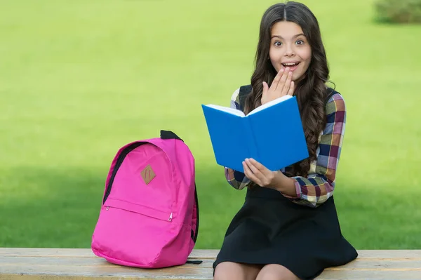 Encontrar inspiración en la lectura. Niño sorprendido leer libro sentado en el banco del parque. Concepto de inspiración. Biblioteca escolar. Educación de alfabetización. Sólo inspirado — Foto de Stock