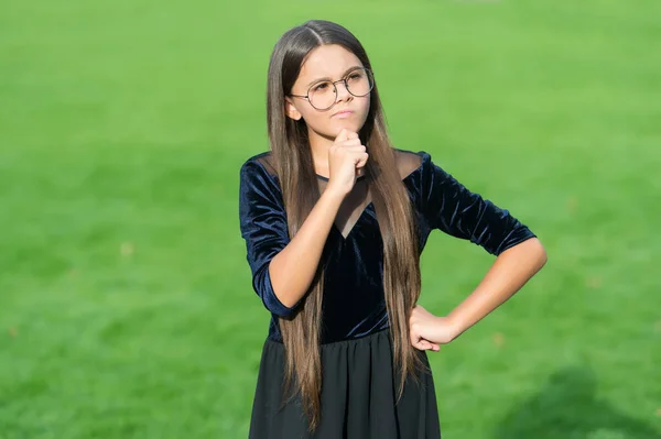 Seriös liten flicka med omtänksam look bära lång brunett hår solig sommar utomhus, hårvård — Stockfoto