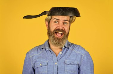 Pişirmeye hazır. Sakallı adam mutfakta yemek yapıyor. Mutfak ve mutfak. Mutfak aletleri. Sağlıklı yemek pişirme. Lezzetli yemek. Sakallı adam kızartma tavasını tutuyor. Tencerede yemek pişirmek. Yemek hazırlamak için.