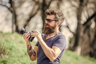 Elle ayarlar. Fotoğrafçı klasik fotoğraf makinesini tutar. Modern blogcu. Sakallı ve bıyıklı bir fotoğrafçı. Adam fotoğraf çekiyor. İçerik yaratan. Sakallı hippi fotoğrafçı. Yaşlı ama hala iyi.