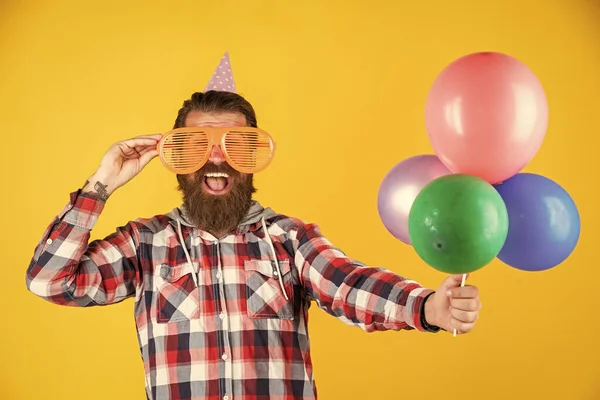 Young and carefree. Party Elements and holiday objects. Multi colored fun. best party for retirement. cheerful man with beard and moustache. hipster smiling with balloon. Celebrating happy party