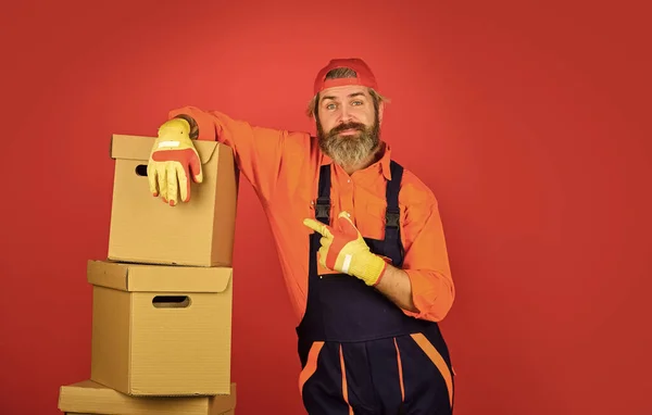 Bewegendes Konzept. Tag des Umzugs. Über den Tellerrand schauen. Express-Lieferkonzept. Ein Arbeiter im Boilersuit an der Box. Umzug in eine neue Wohnung. New Wave of Living. Box für Werkzeuge — Stockfoto