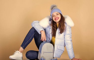 Sıradan bir tarz. Moda aksesuarı. Süslü sırt çantalı güzel bir manken. Küçük bir sırt çantası ve örgü şapka. Mavi pastel kıyafet. Rahat hissediyorum kendimi. Gençlik tarzı. Modern hayat için günlük kıyafet