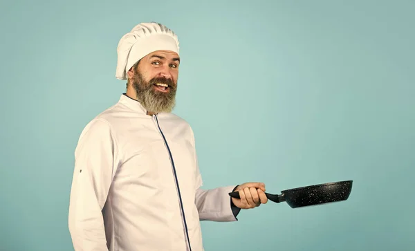 Professional chef. husband in chef hat on kitchen. Cooking food concept. Hold frying pan. best quality. bearded cook in uniform with tools. bearded man hold cooking pan. preparing food in kitchen — Stock Photo, Image