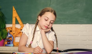 Küçük çocuk okulu. Bilgi toplama günü. Hometask konsepti. Eylülün birinde okula dönüyorum. Öğrenmeye bağlı. Geleceğe doğru hızlanıyor. Şirin kız okuldaki karatahta sınıfında oturuyor.