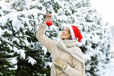 Marketten noel ağacı seçiyorum. Aralık atmosferi. Doğa karla kaplı. Yeni yıl. Mutlu noeller. Boks günü. Kız Noel 'i kutluyor. Kış tatili konsepti. Kadın sıcak giysileri, karlı orman.