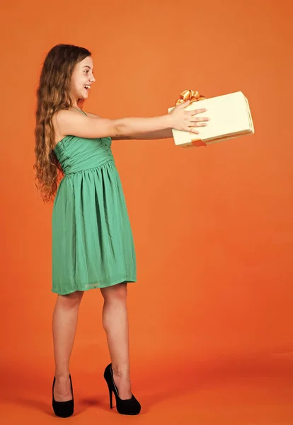 Para ti. niño en el día de verano sobre fondo naranja. su hora de compras. Niña pequeña sostiene la caja de regalo. niño pequeño con caja de regalo. Feliz fiesta de cumpleaños. felicidad infantil. celebremos la fiesta —  Fotos de Stock