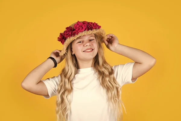 Meisje met strohoed op gele achtergrond. Gelukkige jeugd. Vrouwelijke kapsalon. mooi meisje met bloemen. klein meisje dragen hoed met roze verse bloeiende rozen. bloemsamenstelling. Alleen biologisch — Stockfoto