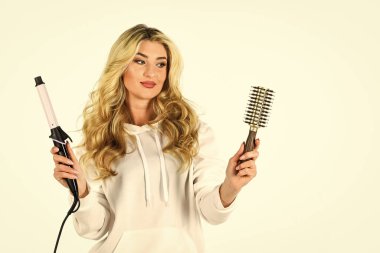 Kuaför ipuçları. Saç stilini saç maşasıyla oluşturun. Uzun kıvırcık saçlı kadın saç maşası kullanıyor. Sevimli sarışın kız. Alet al. Çevrimiçi iş. Kullanışlı saç maşası. Herkes bilmeli.