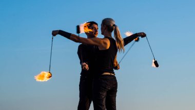 Hareket ve alev sanatı. Çift yanan poi mavi gökyüzü. Ateş sanatı festivali. Ateşli poi salınımı. Yangın gösterisi. Kültür ve spor. Eğlence ve eğlence. Tatil kutlaması. Sıcak dans