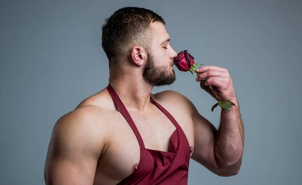 Bel homme porter tablier de cuisine odeur rouge rampe fower, romance — Photo