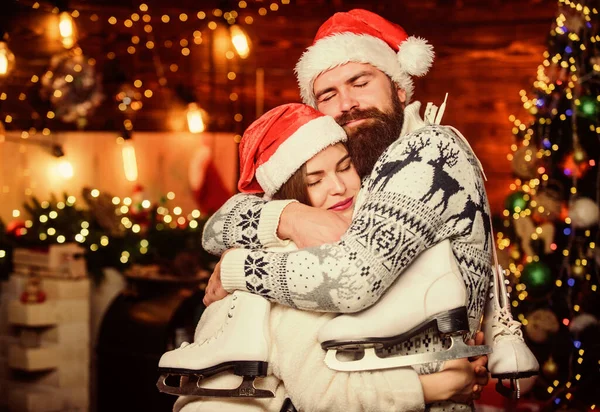 Christmas gift. Winter holidays. Family leisure. Active winter. Winter sports. Happy couple with figure skates. Thankful satisfied. Bearded man and Santa girl. Equipment outdoor sport. Happy together