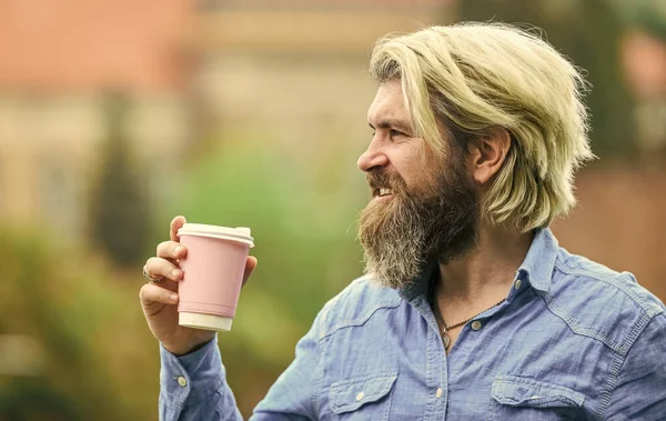 Pequeno-almoço saboroso. homem barbudo bebendo café enquanto caminhava ao ar livre. cara hipster barbudo vestindo roupas casuais gosta de relaxar no fim de semana. conceito de bebidas matinais. estudante em coffee break — Fotografia de Stock