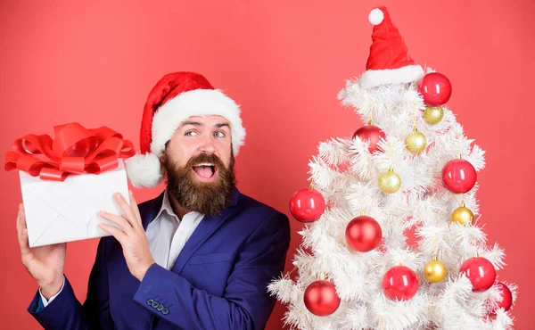 Ανοίγει. χειμερινές πωλήσεις. Χριστουγεννιάτικα ψώνια. γενειοφόρος άντρας με καπέλο Άι Βασίλη. Πρωτοχρονιάτικη έκπληξη. Ο άνθρωπος γιορτάζει πάρτι στο χριστουγεννιάτικο δέντρο. Στείλτε ή λάβετε χριστουγεννιάτικο δώρο. Γρήγορη παράδοση δώρων. Καλές γιορτές. — Φωτογραφία Αρχείου