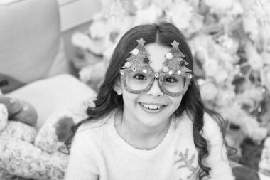 İyi titreşimler. Kış tatili Noel tatilinde evde küçük bir kız. Tasasız çocukluk. Çocuk dinleniyor. Sevimli küçük kız noel ağacı gözlükleri takıyor. Dinlen ve rahatla. Noel arifesi